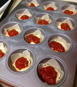 A generous tablespoon of the sausage sauce goes on top of the ricotta filling.